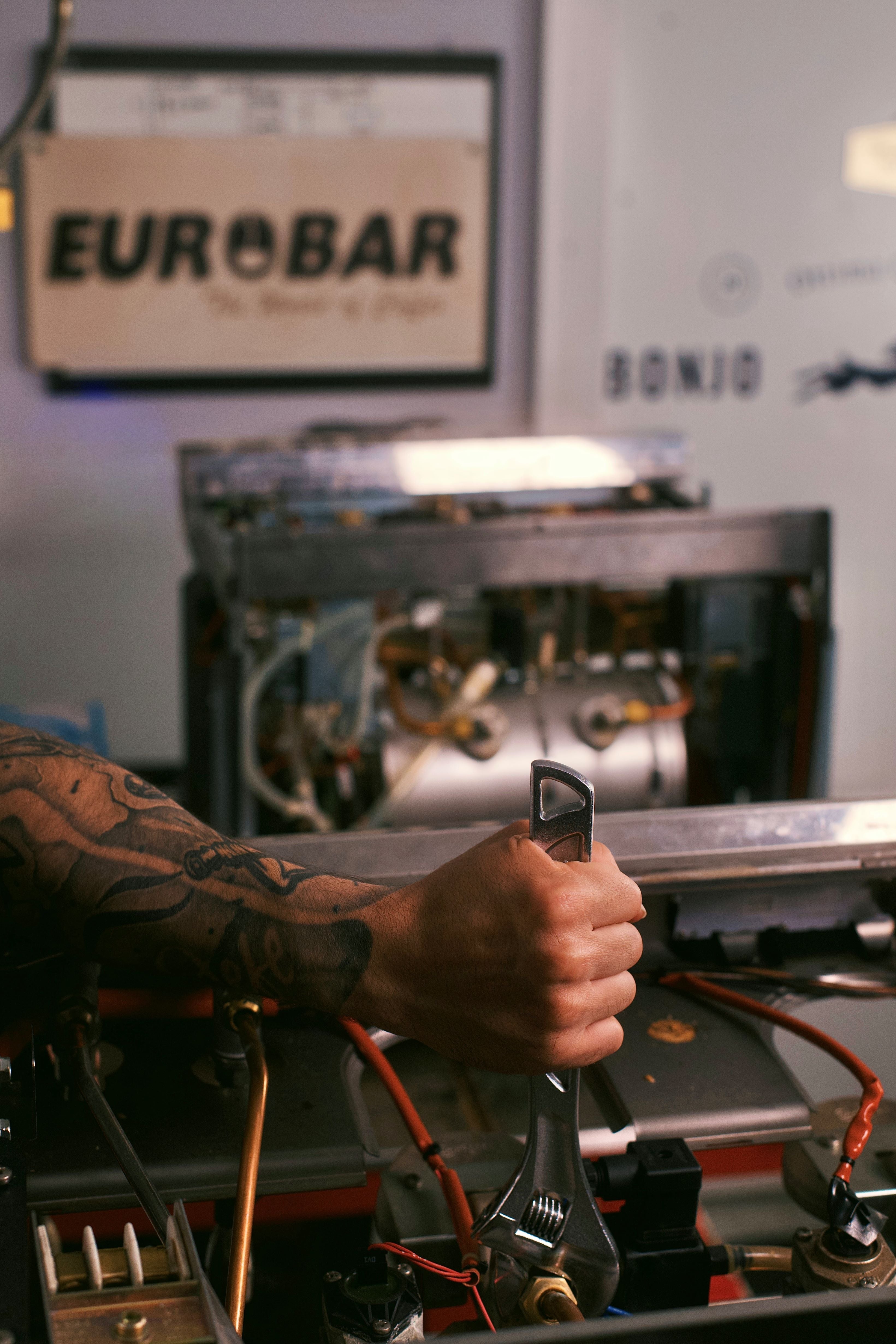 Person operating a coffee machine with 'Eurobar' branding in the background